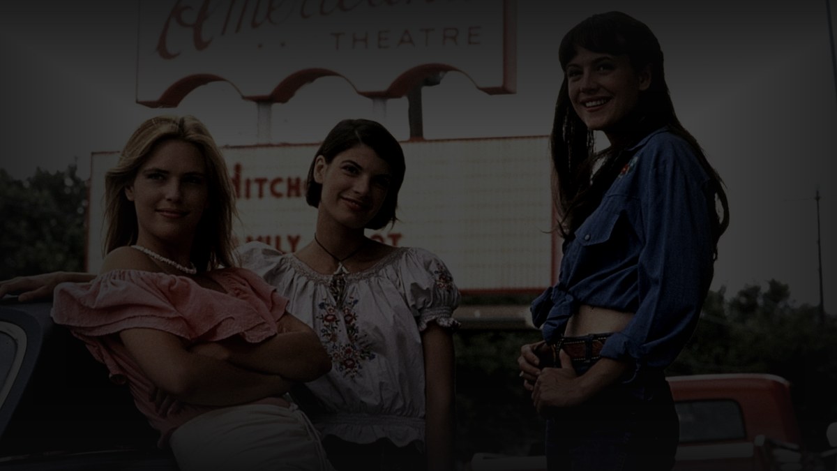 Still from Dazed and Confused (1993) — tmdb backdrop (key jBz16NsAeKjpHNznl1EHlcr704P); genuine production still, the theatre marquee scene. source luma 150.7, pre-darkened 0.60, baked at factor 0.45, lanczos to 1200x675, on-disk luma 30.9
